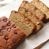 almond flour banana bread sliced on white cutting board.