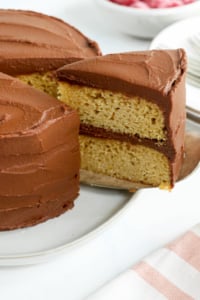 a slice of almond flour cake with chocolate frosting is being lifted out