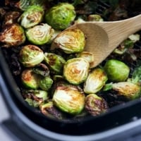 brussels sprouts in half in air fryer with spoon