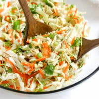 cabbage salad in bowl with tongs