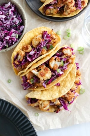 cauliflower tacos on parchment paper with purple slaw