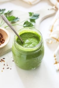 chimichurri sauce in a jar with a spoon