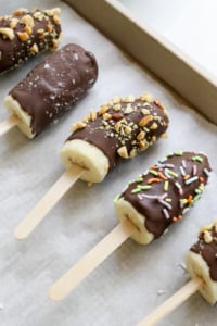 chocolate covered bananas on a baking sheet.