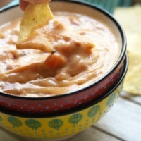 Dipping chip in sweet potato queso dip
