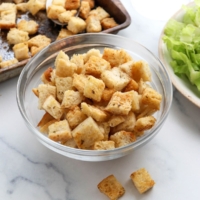 homemade croutons in glass bowl by salad