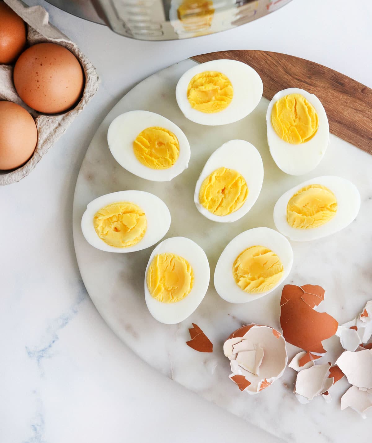 Instant Pot hard boiled eggs cut in half on a marble board