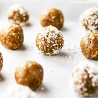 nut free date ball with half rolled in coconut on pan