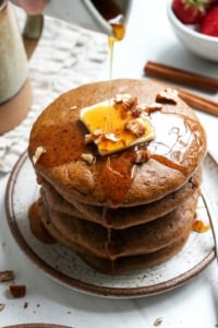 paleo pumpkin pancakes stacked with butter and syrup poured on top