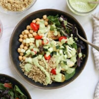 quinoa bowl topped with veggies and dressing.