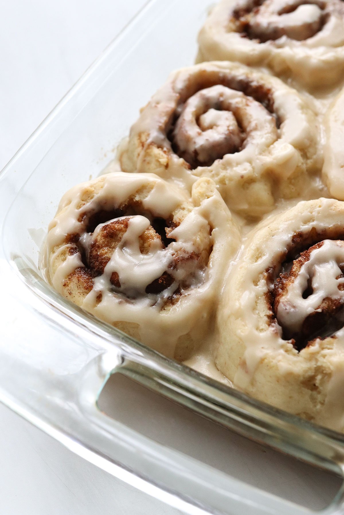 gluten free cinnamon rolls in glass baking dish.