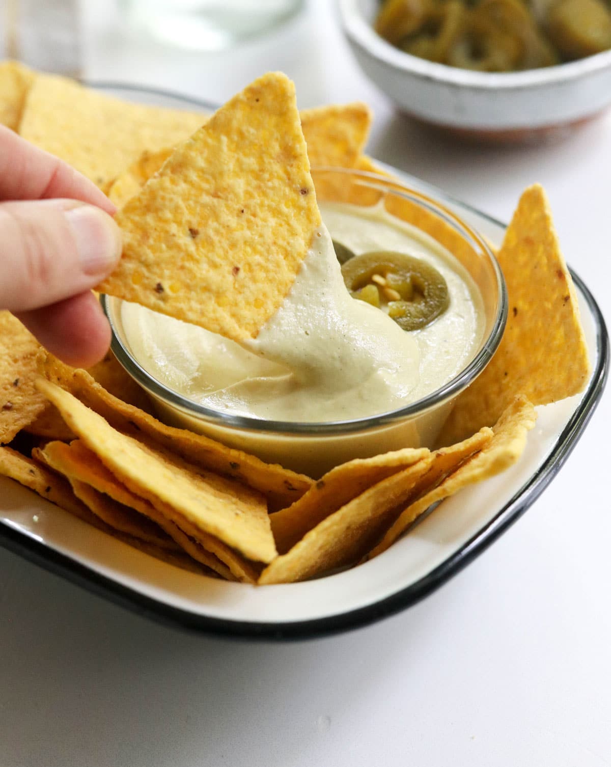 chip dipped in vegan nacho cheese sauce