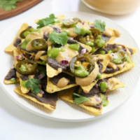 vegan nachos on a white plate with cilantro on top