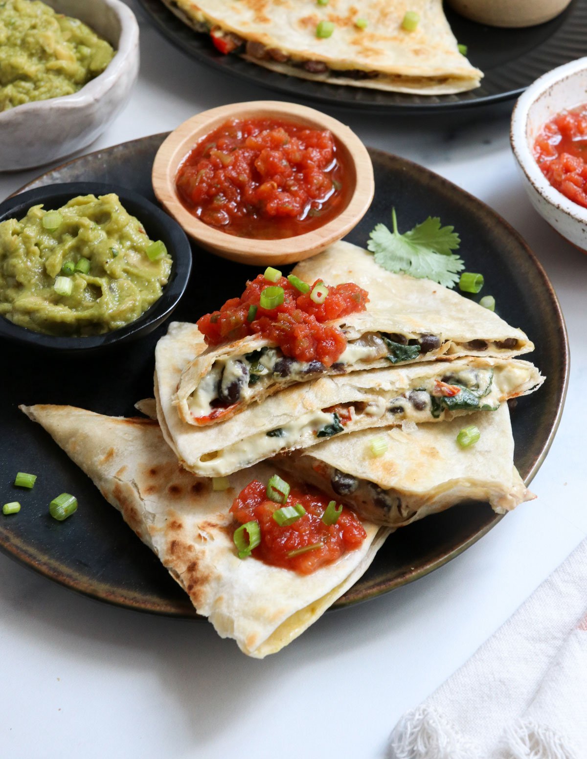 vegan quesadilla triangles stacked on a plate