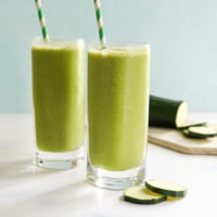 zucchini smoothie in two glasses with straws